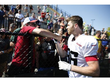 Ottawa RedBlacks #86 Simon Le Marquand greets a fan after an intrasquad game at the Mont-Bleu Sports Complex in Gatineau on Saturday, June 7, 2014.