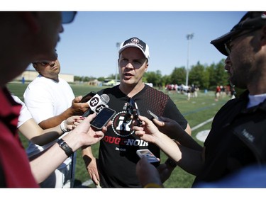 Ottawa RedBlacks coach Rick Campbell is scrummed after an intrasquad game at the Mont-Bleu Sports Complex in Gatineau on Saturday, June 7, 2014.