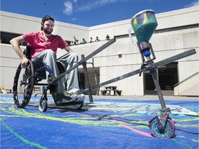 Ottawa rehab patient, Brett Nugent, helps create a large mural with his wheelchair using artist Jeff Nachtigall's innovative Mobile Painting Device at the Ottawa Rehabilitation Centre on Friday