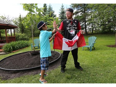 Para-snowboarder John Leslie gets a high five from Jeremy Kilabuk, 11, as Manoir Ronald McDonald House Ottawa welcomed Canadian Olympians and Paralympians to the House as part of the 2014 Celebration of Excellence for the athletes and the 30th anniversary of the House. Jeremy is currently staying at the Ronald McDonald House while John Leslie was a resident 10 years ago when he lost a leg to cancer.