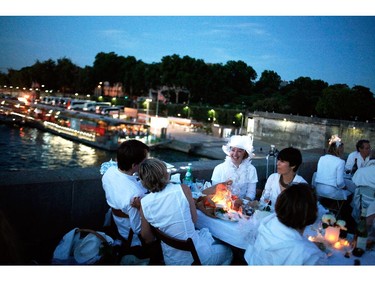 Participants dressed in white take part in Diner en Blanc, or White Dinner, at the Invalides gardens, in Paris, Thursday, June 12, 2014. The event is a reminiscent of flash mobs, where hundreds of people descend on one area at a specific time, summoned by SMS text message, gsm phone call or email.