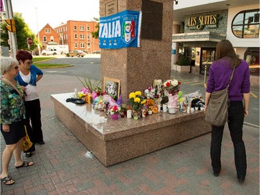 Passersby stop on Monday, June 9, 2014 to view a growing memorial outside Les Suites Hotel in memory of St. Patrick's High School student Brandon Volpi, 18, who was murdered Saturday, June 7 following an after prom party altercation.