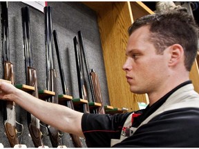 Patrick Deegan, a senior range officer, displays long guns at a gun store in Calgary, Wednesday, Sept. 15, 2010.