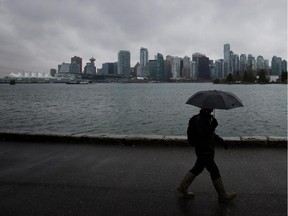 A man shields himself from the rain with an umbrella as he walks along the Stanley Park seawall in Vancouver, B.C., on Sunday January 6, 2013.