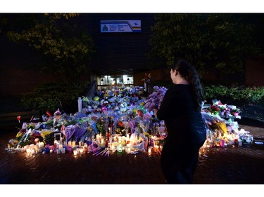 People take part in a candlelight vigil outside RCMP headquarters in Moncton, N.B., on Friday, June 6, 2014. RCMP say a man suspected in the shooting deaths of three Mounties and the wounding of two others in Moncton was unarmed at the time of his arrest early Friday and was taken into custody without incident.