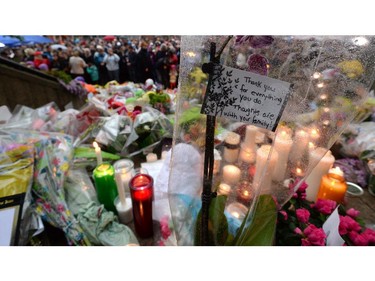 People take part in a candlelight vigil outside RCMP headquarters in Moncton, N.B., on Friday, June 6, 2014. RCMP say a man suspected in the shooting deaths of three Mounties and the wounding of two others in Moncton was unarmed at the time of his arrest early Friday and was taken into custody without incident.