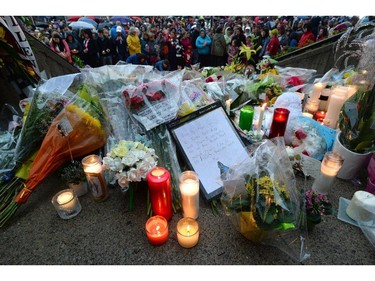 People take part in a candlelight vigil outside RCMP headquarters in Moncton, N.B., on Friday, June 6, 2014. RCMP say a man suspected in the shooting deaths of three Mounties and the wounding of two others in Moncton was unarmed at the time of his arrest early Friday and was taken into custody without incident.