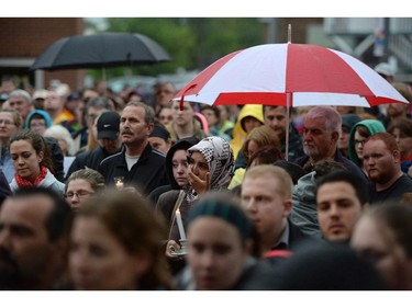 People take part in a candlelight vigil outside RCMP headquarters in Moncton, N.B., on Friday, June 6, 2014. RCMP say a man suspected in the shooting deaths of three Mounties and the wounding of two others in Moncton was unarmed at the time of his arrest early Friday and was taken into custody without incident.