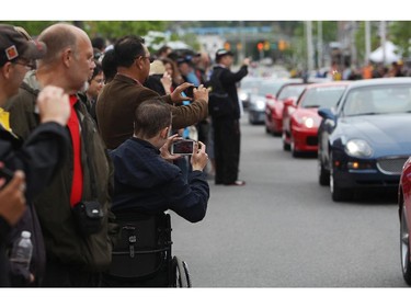 People take photos as italian made cars make their way along Preston St. in Ottawa's Little Italy, during Italian Festival on Saturday, June 14, 2014.