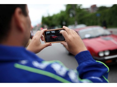 People take photos as italian made cars make their way along Preston St. in Ottawa's Little Italy, during Italian Festival on Saturday, June 14, 2014.