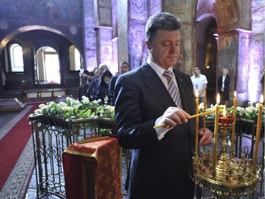 Ukrainian President Petro Poroshenko lights a candle in St. Sophia Cathedral after his inauguration in Kiev, Ukraine, Saturday, June 7, 2014. Poroshenko took the oath of office as Ukraine's president Saturday, calling on armed groups to lay down their weapons as he assumed leadership of a country mired in a violent uprising and economic troubles.