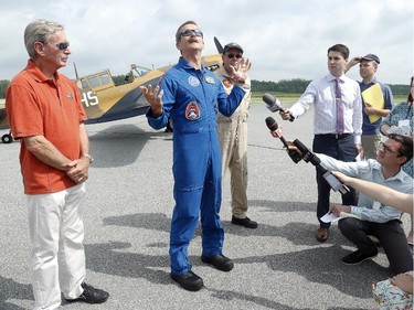 Along with Vintage Wings founder, Mike Potter, left, and brother David, right, Chris Hadfield talks poetically about Canada Day to the media on Monday, June 30, 2014.