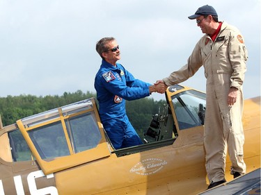 Piloted by his brother, David, right, retired astronaut Chris Hadfield arrived at Gatineau Airport Monday, June 30, 2014 in a Second World War P-40 Kittyhawk.