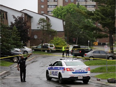 Police investigate a shooting in the 2800 block of Cedarwood Dr. near the Herongate Mall in Ottawa, Tuesday, June 17, 2014. One man is in hospital after being shot. Police say they are looking for a suspect. A pistol was recovered in a green bin near the scene (background). Mike Carroccetto / Ottawa Citizen