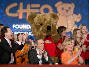 President of CHEO Alex Munter, and Graham Richardson and Carol Anne Meehan from CTV Ottawa applaud after a record total of  $7,121,350 is announced for the CHEO Telethon on June 8, 2014.