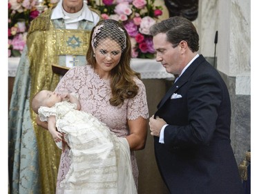 Princess Madeleine holds her daughter Princess Leonore watched by Christopher O'Neill, Princess Leonore's father, during the christening ceremony in the Drottningholm Palace church outside Stockholm, Sweden, Sunday, June 8, 2014.