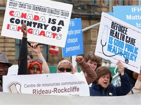 Supporters against federal government cuts to refugee health services protest on Parliament Hill in Ottawa, Monday, June 17, 2013.