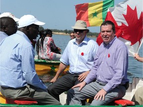 0614 aid groups: Canadian International Development Minister Christian Paradis (Right) takes a boat ride on Lake Rose in Dakar in November, 2013 during a visit to a Canadian-supported aid project.
