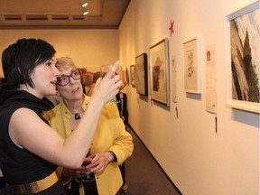Sharon Peake and her mother, Alison, discuss the artwork at the Ottawa Art Gallery's le pARTy auction held Thursday, June 19, 2014, at the Arts Court.