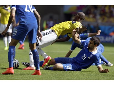 Greece's Sokratis Papastathopoulos (19) trips up Colombia's Victor Ibarbo during the group C World Cup soccer match between Colombia and Greece at the Mineirao Stadium in Belo Horizonte, Brazil, Saturday, June 14, 2014. Papastathopoulos was given a yellow card for the incident.