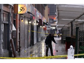 A police investigator collects evidence from the scene May 7, 2009, in Ottawa's Byward Market has left at least one man dead and another injured.