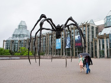 Pedestrians pass by Louise Bourgeois' sculpture Maman (1999) on a rainy day near the main entrance of the National Gallery of Canada. Photo taken at 13:08 on June 13, 2014.