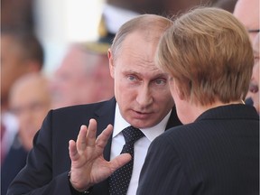Russian President Vladimir Putin and German Chancellor Angela Merkel attend the main international ceremony with 17 heads of state at Sword Beach on June 6, 2014 at Ouistreham, France.