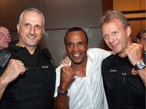 The boys in blue -- Ottawa Police Staff Sgts. Atallah Sadaka, left, and Roger Giasson -- strike a pose with boxing legend Sugar Ray Leonard at the Ringside for Youth XX fundraiser for the Boys and Girls Club of Ottawa, held Thursday, June 12, 2014, at the Ottawa Convention Centre.