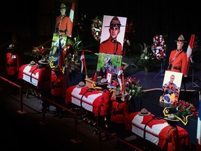 The caskets, from left, of Const. Dave Joseph Ross, 32, of Victoriaville, Que., Const. Douglas James Larche, 40, of Saint John, N.B., and Const. Fabrice Georges Gevaudan, 45, from Boulogne-Billancourt, France, are placed in Moncton's Wesleyan Celebration Centre during the public visitation on Monday.