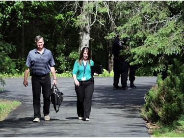 The coroner (left) and a police investigator leave the scene of a fire and death at 170 Grey Fox Dr. in Corkery (Ottawa), Sunday, June 8, 2014.