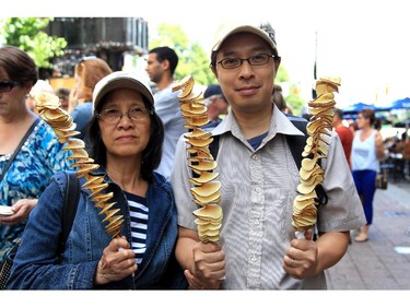Thi Ly Tran and her son Minh Tran with their twisted potatoes at the Ottawa Ribfest on Sunday.