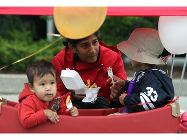 Thusha Agampodi feeds Nico (R) and Ellie (L) some poutine in Westboro in Ottawa, during Westfest on Saturday, June 14, 2014.