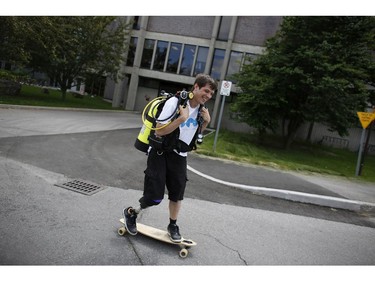 Tim Inglis, a former CHEO cancer patient, skateboards to his car with his scuba diving gear on campus at Carleton University, a short walk from his office where he works for a start up company, on June 6, 2014. Inglis will speak at tomorrow's Doors Open human library at CHEO. He's now a scuba diving instructor for people with disabilities.