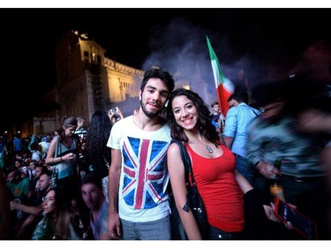 Soccer fans pose in front of a giant screen during the World Cup football match Italy vs England in central Rome's Piazza Venezia on June 14, 2014.