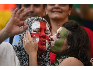 TOPSHOTS  An Italy fan (R) kisses an England fan prior to a Group D football match between England and Italy at the Amazonia Arena in Manaus during the 2014 FIFA World Cup on June 14, 2014.