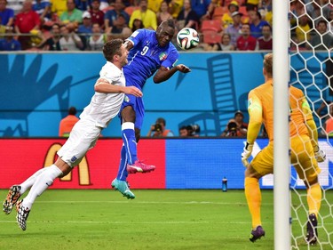 Italy's forward Mario Balotelli (C) heads the ball to score a goal during a Group D football match between England and Italy at the Amazonia Arena in Manaus during the 2014 FIFA World Cup on June 14, 2014.