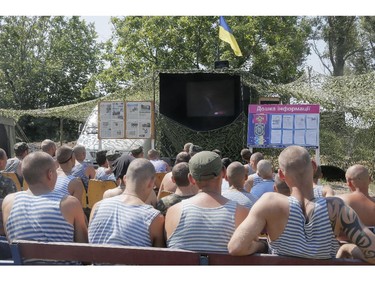 Ukrainian soldiers watch the inauguration ceremony of Ukrainian President-elect  Petro Poroshenko on TV in a tent camp at the Ukraine's Army position close to Slovyansk, Ukraine, Saturday, June 7, 2014. Petro Poroshenko took the oath of office as Ukraine's president Saturday, assuming leadership of a country mired in a violent uprising and economic troubles.