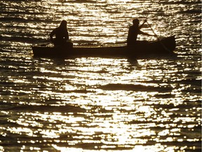 VANCOUVER. OCTOBER 04 2012. A couple paddles out from Kits beach in a canoe as the sun sets Vancouver, October 04 2012.  Gerry Kahrmann  /  PNG staff photo) ( For Prov / Sun News ) [PNG Merlin Archive] ORG XMIT: POS2014062918431475