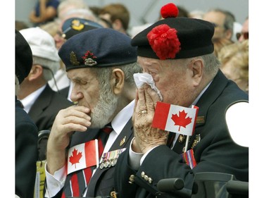 Veterans Bill Hough and Jim Wilkinson (left and right) take part in a moment of silence during a ceremony in Ottawa, Friday June 6, 2014 marking the 70th Anniversary of D-Day and the Battle of Normandy.