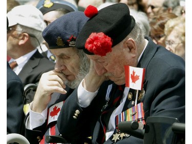 Veterans Bill Hough and Jim Wilkinson (left and right) take part in a moment of silence during a ceremony in Ottawa, Friday June 6, 2014 marking the 70th Anniversary of D-Day and the Battle of Normandy.