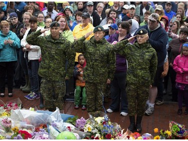 Three soldiers participate in a candle light vigil in Moncton, N.B. on Friday, June 6, 2014 to pay respect to the three RCMP officers who were killed and the two injured in a shooting spree on Wednesday. Justin Bourque, 24, is facing three charges of first-degree murder and two charges of attempted murder.