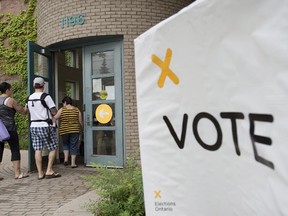 Voters arrive at a polling station in Toronto to cast their vote for the Ontario provincial election on Thursday, June 12, 2014.