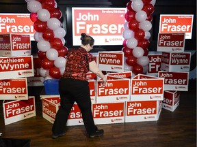 Worker sets up a campaign sign at the Hometown Sports and Grill before the election result announcement for Ottawa South Liberal candidate John Fraser on Thursday, June 12, 2014. (James Park / Ottawa Citizen)