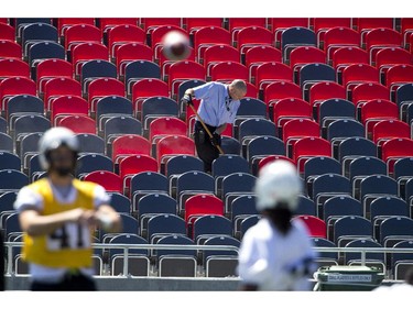 A worker cleans the stands at TD Place as the Redblacks held their final practice on Thursday before road game at Hamilton on Saturday.