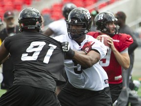 DJ Young tangles with Brandon Lang, No. 91 during Redblacks practice at TD Place Tuesday.
