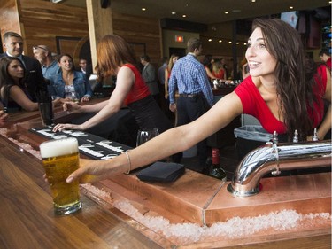 A bartender serves a drink during a ceremonial grand opening of Sens House, the official sports bar of the Ottawa Senators, in the Byward Mark at 73 York St. Thursday, July 24, 2014.