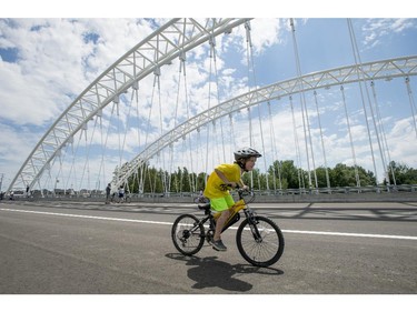 A boy rides his bike across the deck of the Strandherd-Armstrong Bridge during its grand opening, shortly before it become open to vehicular traffic, in Ottawa on Saturday, July 12, 2014. The bridge connects the communities of Barrhaven and Riverside South over the Rideau River.