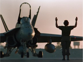 A Canadian CF-18 gets the go-ahead for takeoff at dusk at the military base in Dohar, Qatar on December 3, 1990 .