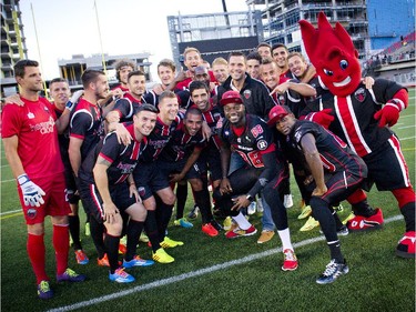 A couple Redblack players take a photo with the Ottawa Fury FC during the official opening of TD Place at Lansdowne Wednesday July 9. 2014.