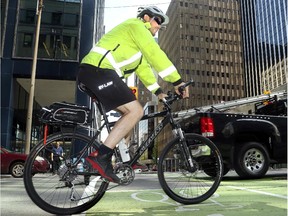 A cycling by-law officer makes his way across Laurier Avenue's bike lanes in Ottawa on May 22, 2014.